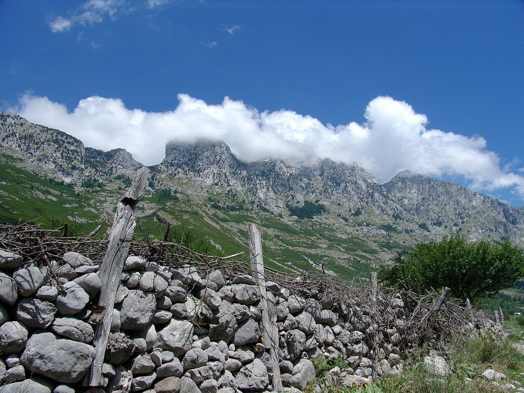 Pod oblačnom kapom. Od prijevoja s lijeva na desno nižu se: Maja e Bridashës (2125 m), Maja Irgut (2182 m), i Kota 2137 m.