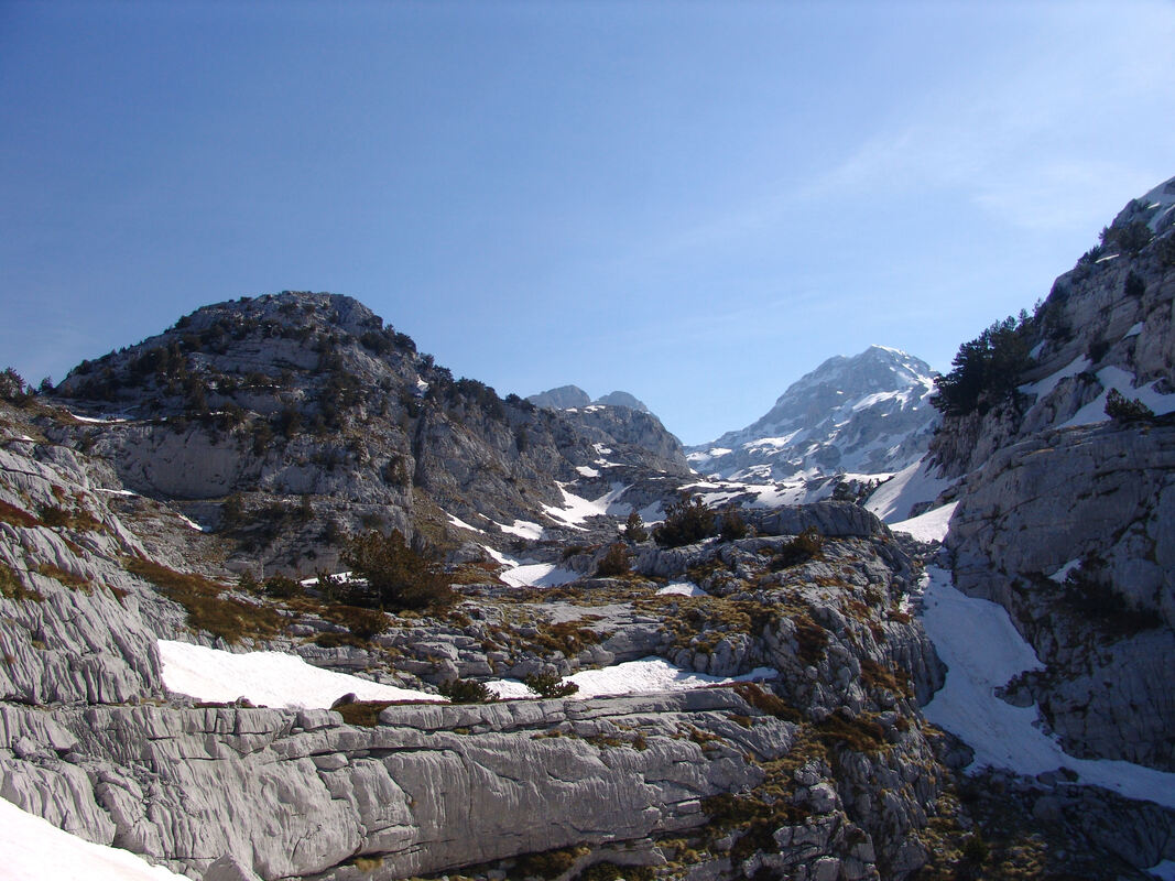 Voda u bezvodnom krajoliku. U usjeku u stijeni, uz mali stjenoviti prijevoj između Kote 2064 m (brijeg lijevo) i padina Maje Irgut (desno), nalazi se mala kamenica s vodom.