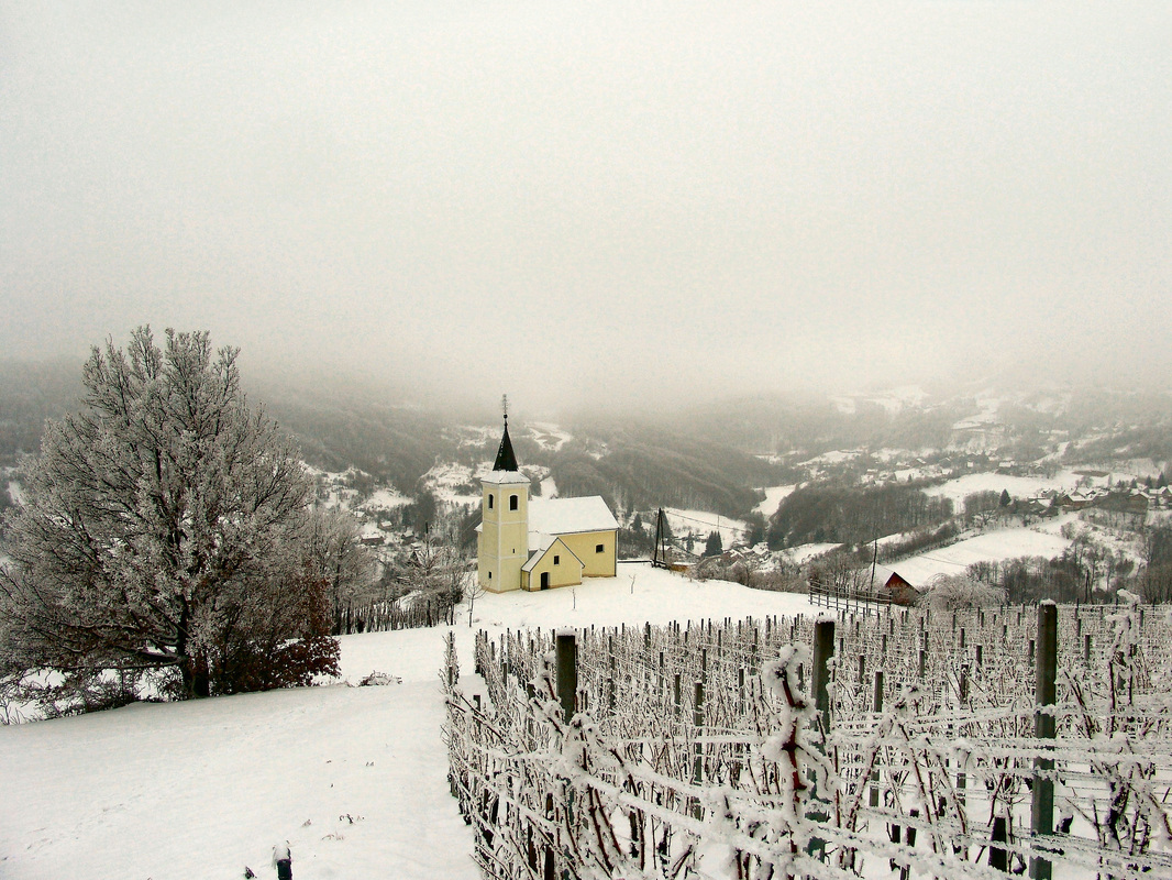 Crkva sv. Trojstva u selu Rude. Desno u uvali nalazi se selo Braslovlje; pogled s upona na Oštrc.