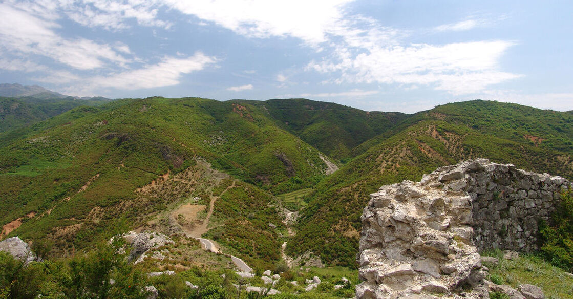 Ostaci srednjovjekovnog grada Drisht / Drivast (desno) i po njom prijevoj Qafa Shpatit. Iza prijevoja (u sredini fotografije) je brdo Kodra Cemit (401 m).