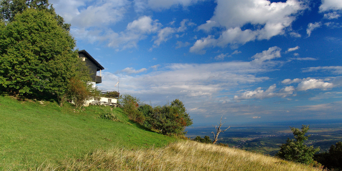 Livada Žitnica na Japetiću. Zgrada planinarskog doma (lijevo) i desno u dubinu pogled prema području Jastrebarskog, Crnoj Mlaki i Pokuplju (na horizontu).