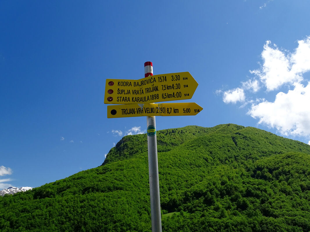 Putokaz s prikazanim udaljenostima hoda, koji se nalazi na području sela Dolje kod Kačanika – prvog uzvišenog prijevoja kojime prolazi cesta od Gusinja prema Grebajama.