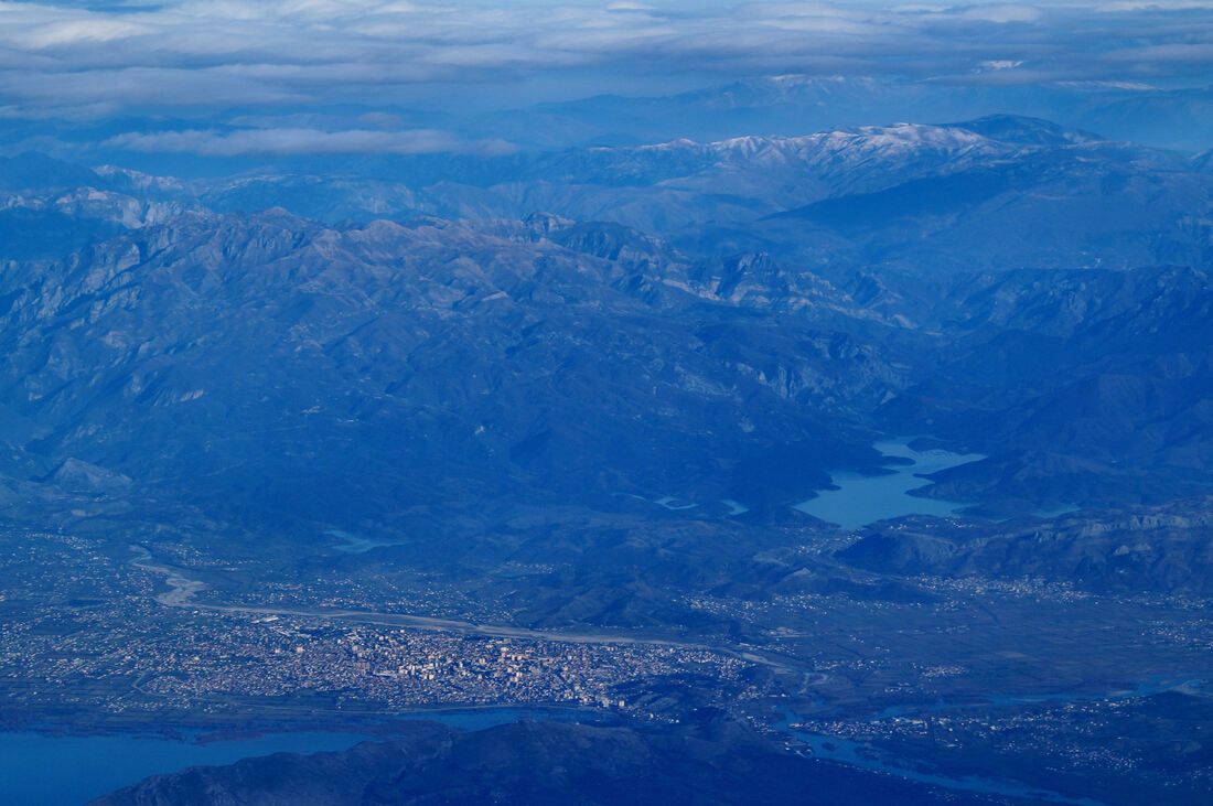 Zračni snimak na kojemu se vidi grad Skadar (u podnožju fotografije) i iza njega masiv Cukalija i akumulacija Vau i Dejës