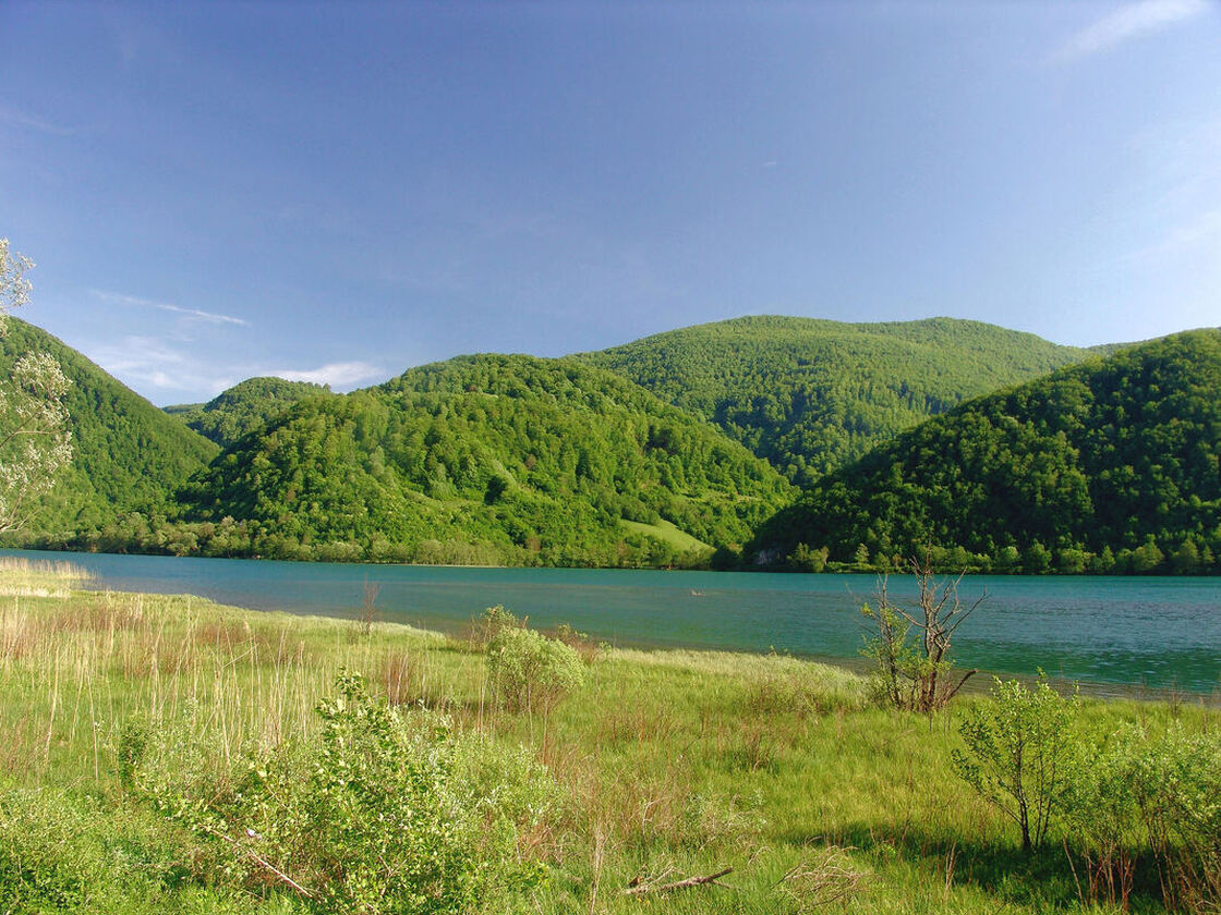 Na suprotnoj strani Plivskog jezera u sredini je brijeg Orlovača (669 m), lijevo od njega malo se nazire Oštro brdo (771 m), a u pozadini se izdiže prostraniji greben s vrhom Čingari (994 m).